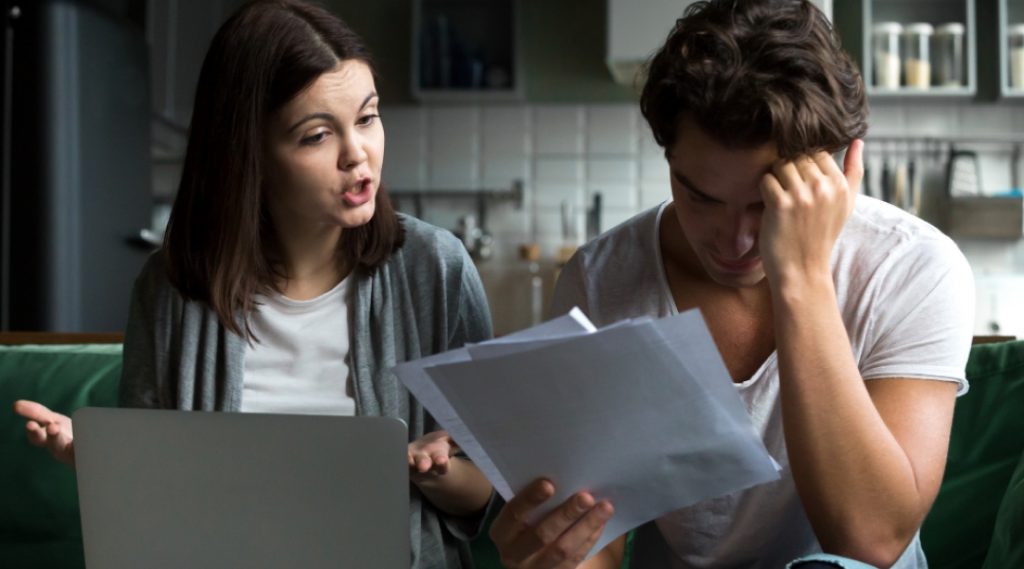 Couple reviewing financial documents with an advisor to explore alternatives before declaring bankruptcy.