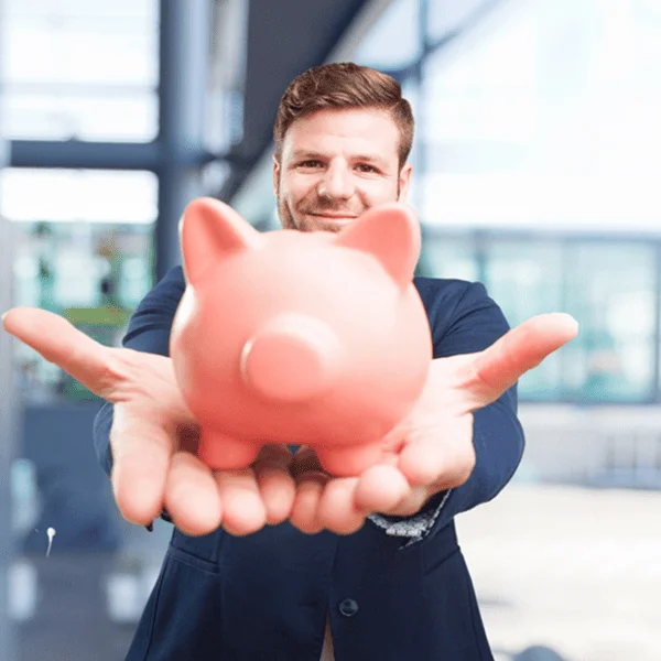 A man in a suit holds a piggy bank, symbolizing savings and financial planning.