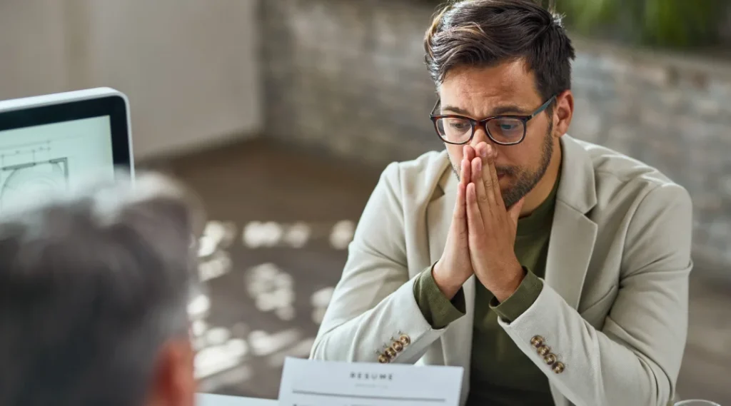 A man sitting at a desk with his hands on his face, reflecting on his role as a leading insolvency trustee.