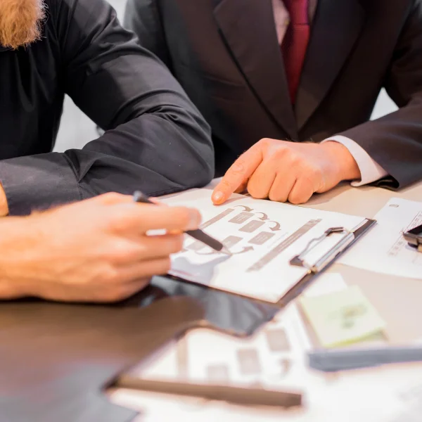 Two business professionals seated at a table, reviewing papers related to insolvency matters.