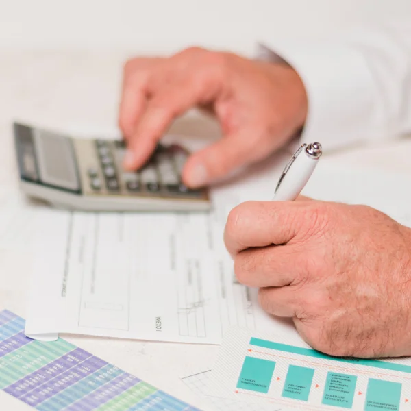 A man writes on paper, focusing on debt consolidation strategies.