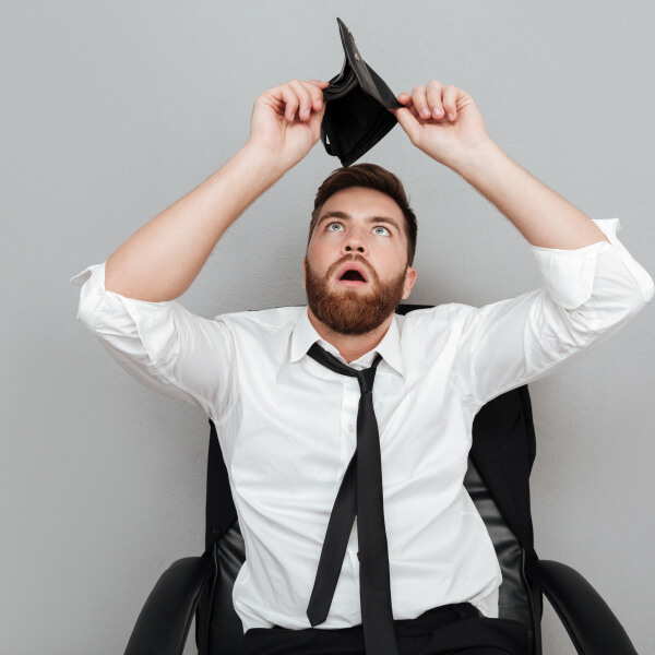 Un homme en chemise et cravate tient un portefeuille noir dans ses mains.